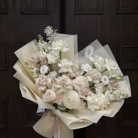 The "Whipped Cream" bouquet from our regular collection offers a serene and elegant arrangement in natural hues of light beige and white. Wrapped in soft beige paper, it exudes a gentle charm, perfect for creating a calming ambiance or celebrating special moments with understated beauty. Its neutral palette makes it an ideal gift for any occasion, reflecting a refined taste and timeless elegance.