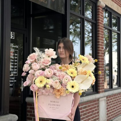 Margarita is a delightful square box arrangement that captures the essence of summer with its beautiful blend of light pink and light yellow flowers. This cheerful combination evokes feelings of warmth and joy, making it the perfect centerpiece for any occasion. Available in medium and large sizes, the Margarita arrangement is designed to bring a touch of brightness and elegance to any space, whether as a gift or a stunning decorative piece in your home. Each box is carefully crafted to showcase the delicate beauty of the flowers, creating a fresh and inviting atmosphere that celebrates the joys of the season.