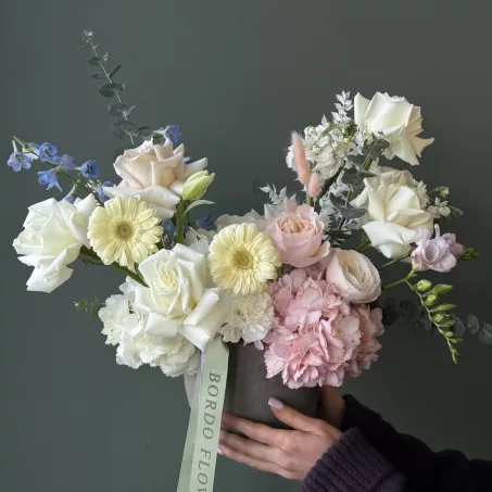 Vase "Lacy Bird" – a sophisticated statement of timeless elegance in soft pinks and whites, created in a sleek, modern grey beton vase. This premium arrangement combines the delicate beauty of ranunculuses and garden roses, blending their lush petals for a refined and luxurious look. Perfect for adding a touch of elegance to any space, Vase Bloom is part of our exclusive collection, capturing the essence of understated beauty and refined taste.